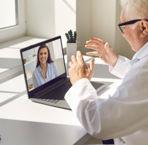 Dokter sedang melakukan konsultasi medis online dengan pasien melalui laptop sebagai bentuk inovasi telemedis.
